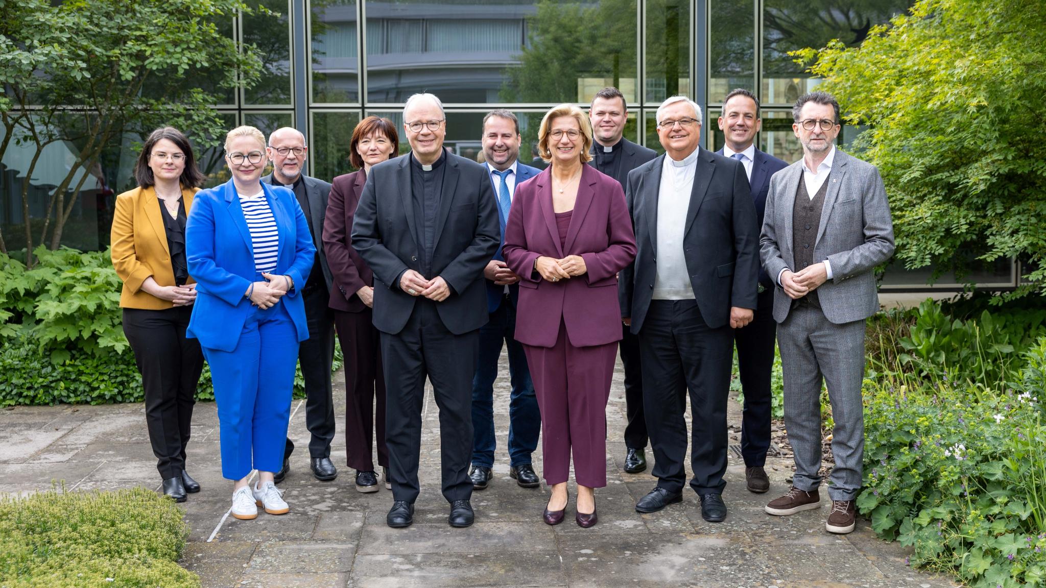 Eine Gruppe aus Frauen und Männern lächelt in die Kamera